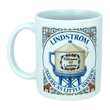 Show your Lindström pride with the Mug: Lindstrom America's Little Sweden Ceramic Coffee Mug (11 oz) by Nordic Wholesale. This white ceramic mug features a decorative illustration of a water tower labeled "Lindström," adorned with Swedish-style floral accents inspired by Scandinavian folk art, along with the phrases "Välkommen till Lindström" and "America’s Little Sweden." A charming keepsake or gift for anyone celebrating their Lindström roots and Swedish heritage.