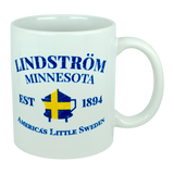 This 11 oz white ceramic mug from Nordic Wholesale features blue text that reads "Lindstrom Minnesota EST 1894 America’s Little Sweden," along with a yellow and blue Swedish flag shaped like the state of Minnesota. The perfect mug for anyone proud of their Lindstrom roots and Swedish heritage. Product name: Mug: Lindstrom Minnesota America's Little Sweden Ceramic Mug (11 oz Capacity).
