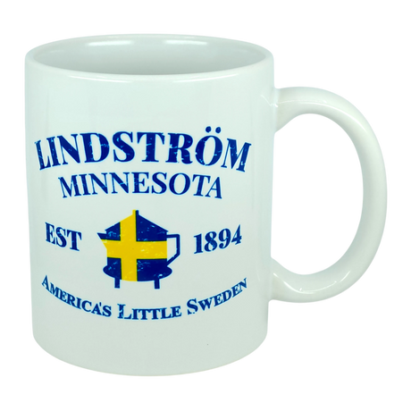 This 11 oz white ceramic mug from Nordic Wholesale features blue text that reads "Lindstrom Minnesota EST 1894 America’s Little Sweden," along with a yellow and blue Swedish flag shaped like the state of Minnesota. The perfect mug for anyone proud of their Lindstrom roots and Swedish heritage. Product name: Mug: Lindstrom Minnesota America's Little Sweden Ceramic Mug (11 oz Capacity).