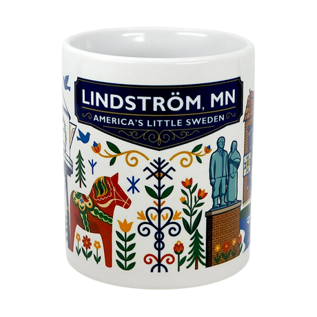 The Swedish Gift Store's 11oz Lindstrom, MN — America's Little Sweden mug features vibrant Scandinavian folk art, a Dala horse, landmarks, and "Lindström, MN" on a blue banner—an ideal ceramic souvenir or Swedish-themed gift.