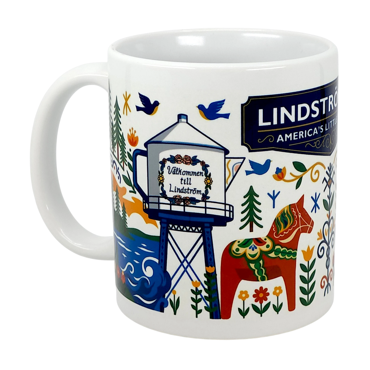 The 11oz ceramic “Lindstrom, MN — America’s Little Sweden” mug by Swedish Gift Store showcases vibrant Scandinavian folk art with a horse, trees, birds, and the town’s water tower reading “Välkommen till Lindström.”.