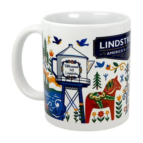 The 11oz ceramic “Lindstrom, MN — America’s Little Sweden” mug by Swedish Gift Store showcases vibrant Scandinavian folk art with a horse, trees, birds, and the town’s water tower reading “Välkommen till Lindström.”.