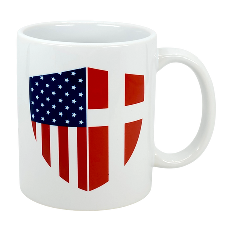 The Swedish Gift Store’s "Mug: Made in America with Danish Parts Ceramic Mug (11 oz)" is a white ceramic coffee cup featuring a shield design with the American flag on the left and Danish flag on the right.