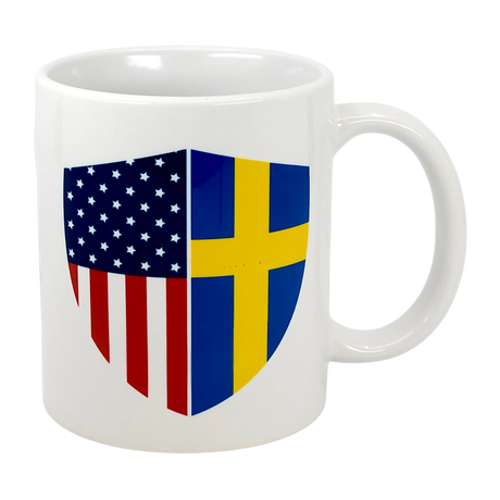 Celebrate your heritage with the "Made in America with Swedish Parts" 11 oz ceramic mug by Swedish Gift Store, featuring a split American and Swedish flag shield—perfect for dual-flag pride.