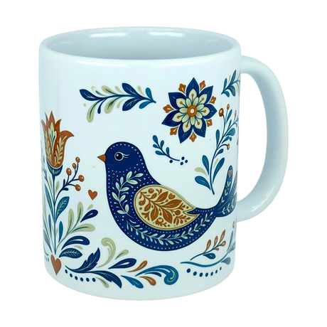 Introducing the Mug: Nordic Folk Art Birds Ceramic Mug (11 oz Capacity) by Nordic Wholesale—a white ceramic mug adorned with a decorative blue bird accented in orange and gold, surrounded by floral patterns in blue, orange, and green. Inspired by classic Nordic rosemaling designs, this folk art mug blends timeless Scandinavian charm with vibrant detailing. The handle is finished in plain white.