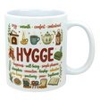 Ceramic coffee cup with the word “HYGGE” and Scandinavian-style illustrations of a fireplace, socks, teapot, chair, and book.