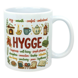Ceramic coffee cup with the word “HYGGE” and Scandinavian-style illustrations of a fireplace, socks, teapot, chair, and book.
