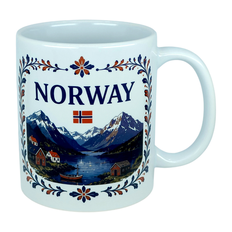 The Nordic Wholesale Mug: Norway Fjord Mountain Ceramic Mug (11 oz Capacity) features the word "NORWAY" and a Norwegian flag above a scenic illustration of mountains, water, boats, and houses, all framed by blue and orange floral patterns inspired by traditional rosemaling. This ceramic mug beautifully celebrates Norwegian heritage with its intricate design.