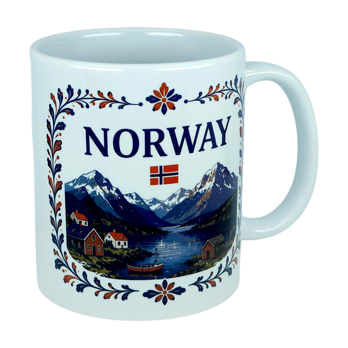 The Nordic Wholesale Mug: Norway Fjord Mountain Ceramic Mug (11 oz Capacity) features the word "NORWAY," a small Norwegian flag, and a detailed illustration of mountains, a fjord, houses, trees, and a boat. The design is framed by an elegant floral border inspired by traditional rosemaling. This charming mug beautifully celebrates Norwegian heritage with every sip.