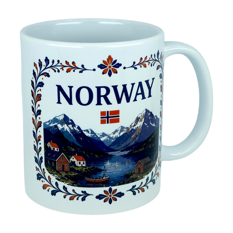 The Nordic Wholesale Mug: Norway Fjord Mountain Ceramic Mug (11 oz Capacity) features the word "NORWAY," a small Norwegian flag, and a detailed illustration of mountains, a fjord, houses, trees, and a boat. The design is framed by an elegant floral border inspired by traditional rosemaling. This charming mug beautifully celebrates Norwegian heritage with every sip.