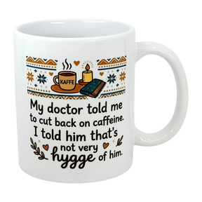 The Swedish Gift Store's 11 oz "Not Very Hygge" Coffee Mug features Nordic patterns and text: My doctor told me to cut back on caffeine. I told him that's not very Scandinavian humor—or hygge coffee mug—of him.