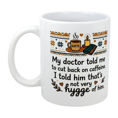 The Swedish Gift Store’s 11 oz “Not Very Hygge” Coffee Mug features Nordic illustrations and the text: “My doctor told me to cut back on caffeine. I told him that’s not very hygge of him.” A cozy touch of Scandinavian humor!.