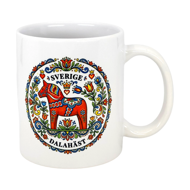 The "Sverige Dala Häst" Mug by Swedish Gift Store features a red Dala horse framed by a Swedish folk art wreath, with “Sverige” and “Dalahäst” stylishly displayed above and below the design. 11 oz ceramic.