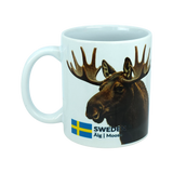 The Mug: Sweden Älg Moose Ceramic Mug (11 oz) by Nordic Wholesale features a white design with a photo of a moose's head, the Swedish flag, and the words "SWEDEN Älg | Moose" printed on it—making it a charming addition to any Scandinavian kitchen and an ideal tribute to Nordic nature.