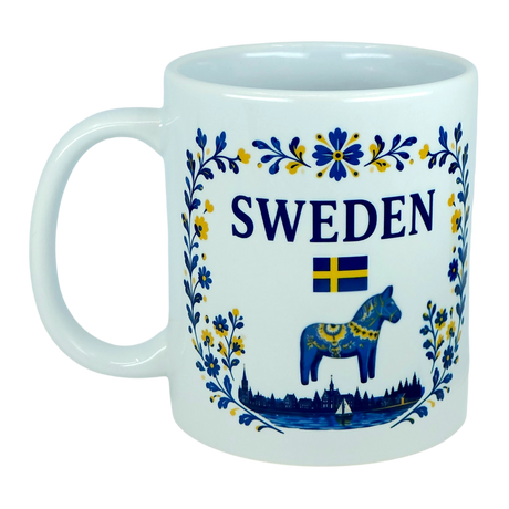 Celebrate your love for Swedish heritage with the Nordic Wholesale Mug: Sweden Dala Horse Ceramic Mug (11 oz Capacity). This beautifully crafted white ceramic mug showcases blue and yellow floral designs, the word "Sweden," a Swedish flag, and a striking blue Dala horse on the front, perfectly capturing Scandinavian folk tradition and charm—an ideal addition to any collection.