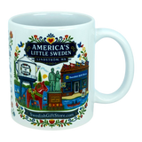 The Nordic Wholesale Mug: Swedish Gift Store America's Little Sweden Ceramic Mug (11 oz) is a white ceramic mug in a charming Nordic style, featuring colorful illustrations of Lindström, Minnesota—including the town’s iconic water tower, Swedish horse, local store, statues, and floral patterns. The mug displays the text "America's Little Sweden, Lindström, MN," making it a perfect Swedish-American gift for celebrating your heritage or love of Scandinavian design.