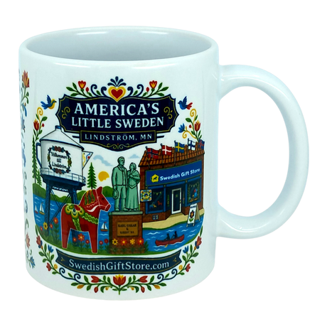The Nordic Wholesale Mug: Swedish Gift Store America's Little Sweden Ceramic Mug (11 oz) is a white ceramic mug in a charming Nordic style, featuring colorful illustrations of Lindström, Minnesota—including the town’s iconic water tower, Swedish horse, local store, statues, and floral patterns. The mug displays the text "America's Little Sweden, Lindström, MN," making it a perfect Swedish-American gift for celebrating your heritage or love of Scandinavian design.
