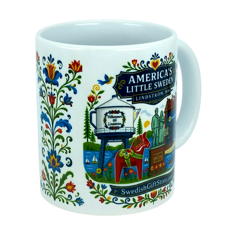 Nordic Wholesale’s “America’s Little Sweden” ceramic mug (11 oz) from Swedish Gift Store features vibrant Swedish folk art, including Lindstrom, Minnesota landmarks and iconic Dala horse imagery. The charming white mug also displays the website SwedishGiftStore.com.