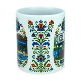 Experience the charm of Swedish-American heritage with the Mug: Swedish Gift Store America's Little Sweden Ceramic Mug (11 oz) by Nordic Wholesale, featuring colorful, symmetrical floral designs and partial illustrations of iconic buildings and signs inspired by a Swedish gift store. This white ceramic mug is thoughtfully adorned to celebrate every detail of "America's Little Sweden.