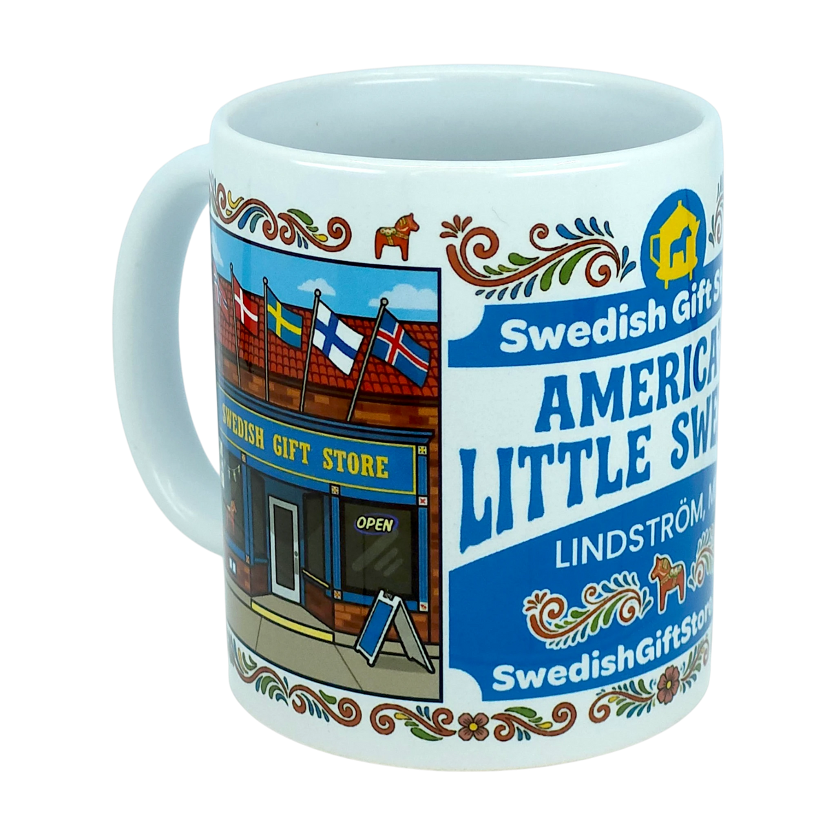 Enjoy your favorite beverage with the Mug: Swedish Gift Store America's Little Sweden Wraparound Ceramic Mug (11 oz) by Nordic Wholesale. This white ceramic mug features a vibrant storefront labeled "Swedish Gift Store," highlighted by Scandinavian flags, decorative Swedish folk art, and a delightful Dala horse design. The text reads "America's Little Sweden" and "Lindström," making it the perfect piece to celebrate your Swedish-American heritage.