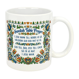 The Nordic Wholesale 11 oz Swedish Table Prayer Ceramic Kurbits Mug features colorful Swedish folk art, Kurbits floral design, small Swedish flags, and the Table Prayer printed in both Swedish and English at the center.