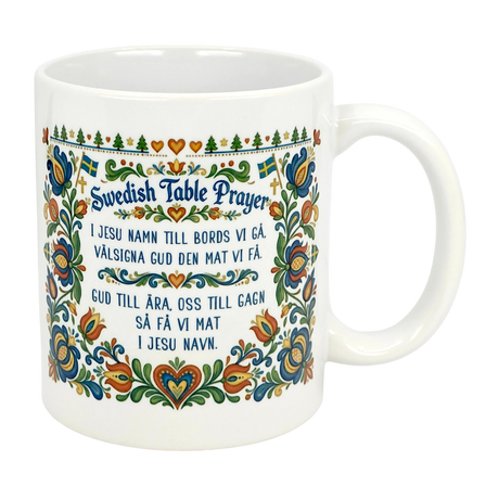 The Nordic Wholesale 11 oz Swedish Table Prayer Ceramic Kurbits Mug features colorful Swedish folk art, Kurbits floral design, small Swedish flags, and the Table Prayer printed in both Swedish and English at the center.