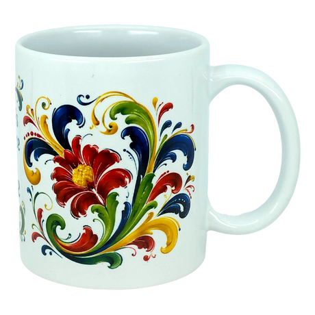 The Mug: There's No Place Like Home Rosemaling Ceramic Mug (11 oz) by Nordic Wholesale is a white ceramic coffee mug adorned with a vibrant floral and leaf pattern in red, yellow, green, and blue hues, inspired by classic Scandinavian folk art designs.