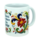 Introducing the Mug: There's No Place Like Home Rosemaling Ceramic Mug (11 oz) by Nordic Wholesale—a white ceramic coffee mug adorned with vibrant red, yellow, green, and blue floral motifs and scrolling patterns inspired by Scandinavian folk art. Part of the design includes the phrase "There's no place like home," while the handle remains plain.