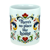The Nordic Wholesale "There's No Place Like Home" Rosemaling Ceramic Mug (11 oz) is a white ceramic coffee mug featuring vibrant Scandinavian folk art-inspired floral designs and "There's no place like home" written in blue on the front.
