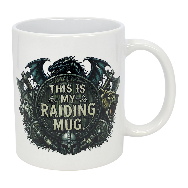 The Nordic Wholesale Mug: This Is My Raiding Mug Viking Ceramic Mug (11 oz) is a white ceramic mug with a dragon, wolf, and bear around a shield reading "This Is My Raiding Mug," surrounded by Norse and Viking-style designs.