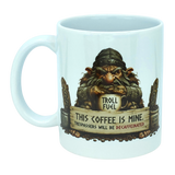 Introducing the Troll Fuel Ceramic Coffee Mug (11 oz Capacity) from Nordic Wholesale. This whimsical ceramic mug showcases a grumpy troll inspired by classic Nordic folklore, grasping a cup labeled "Troll Fuel." Accented with decorative details and coffee beans, the design features bold text: "THIS COFFEE IS MINE. TRESPASSERS WILL BE DECAFFEINATED." Perfect for adding Scandinavian charm to your coffee ritual.