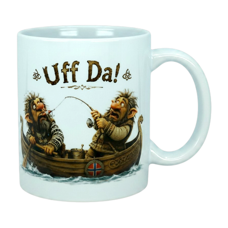 The Mug: Uff Da Fishing Trolls Ceramic Mug (11 oz Capacity) from Nordic Wholesale features two cartoon trolls in a Viking boat—one fishing while the other reacts in surprise—with "Uff Da!" printed above them, capturing classic Scandinavian humor.