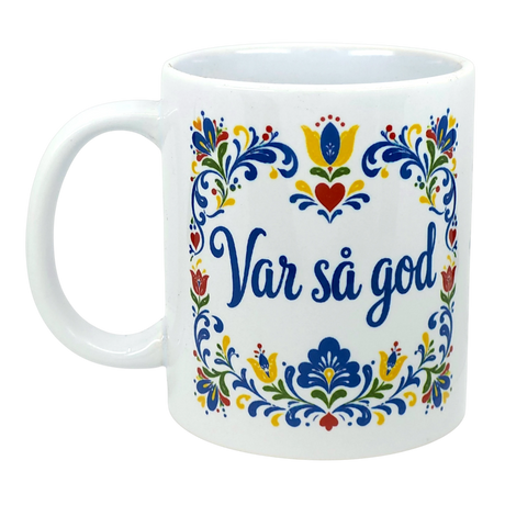 White mug with colorful floral patterns and the Swedish phrase “Var så god” in blue script, featuring Scandinavian folk art design elements.