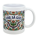 The Mug: Var Sa God Swedish Kurbits Folk Art Ceramic Mug (11 oz) by Nordic Wholesalers features colorful, traditional Swedish folk art floral designs and the phrase "Var så god" in bold blue at the center.