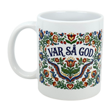 The 11 oz Mug: Var Sa God Swedish Kurbits Folk Art Ceramic Mug by Nordic Wholesalers features colorful Scandinavian floral patterns and the phrase "VAR SÅ GOD" in bold blue letters at the center.