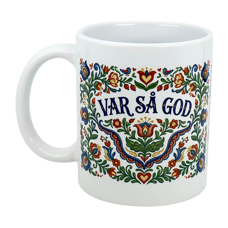 The Swedish Gift Store’s 11 oz Mug: Var Sa God Swedish Kurbits Folk Art Ceramic Mug features vibrant Scandinavian folk art with "VAR SÅ GOD" in bold blue at the center.