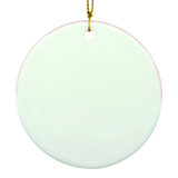 Round white ceramic ornament with a small hole at the top, suspended by a thin gold string, in front of a white background. Nordic folk art inspiration.