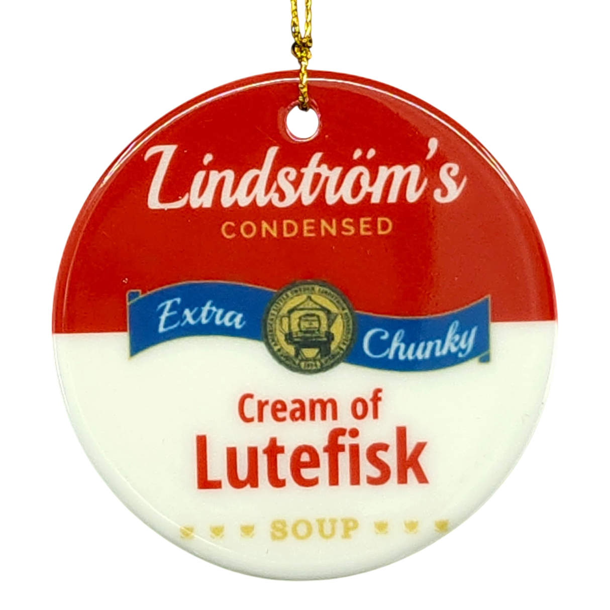 Round ornament styled like a soup can label, text reads Lindströms Condensed Extra Chunky Cream of Lutefisk Soup, gold hanging string attached.