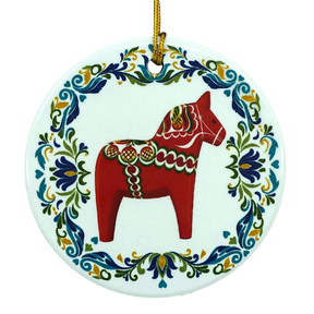 Round ceramic ornament featuring a red Swedish Dala horse with a blue and green floral rosemaling border.