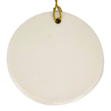 A round white ceramic ornament by Nordic Wholesale, the "Lindstrom Water Tower Floral Ceramic Ornament" (2.875" diameter), hangs against a white background with a gold string looped through a small hole at the top. Its simple elegance offers a subtle nod to kurbits folk art traditions.