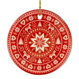 Round red Nordic ornament featuring white snowflake, reindeer, and tree patterns, hanging from a gold string.