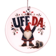 Round ceramic ornament featuring a tomte lifting the text UFF DA over his head with a spilled mug nearby.