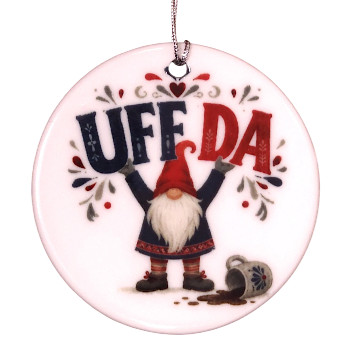 Round ceramic ornament featuring a tomte lifting the text UFF DA over his head with a spilled mug nearby.