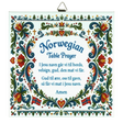 Ceramic wall tile featuring floral rosemaling patterns, Norwegian flags, and a Norwegian Table Prayer in blue text on a white background.