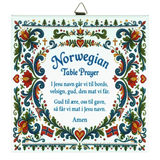 Ceramic wall tile featuring floral rosemaling patterns, Norwegian flags, and a Norwegian Table Prayer in blue text on a white background.