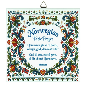 Ceramic wall tile featuring floral rosemaling patterns, Norwegian flags, and a Norwegian Table Prayer in blue text on a white background.