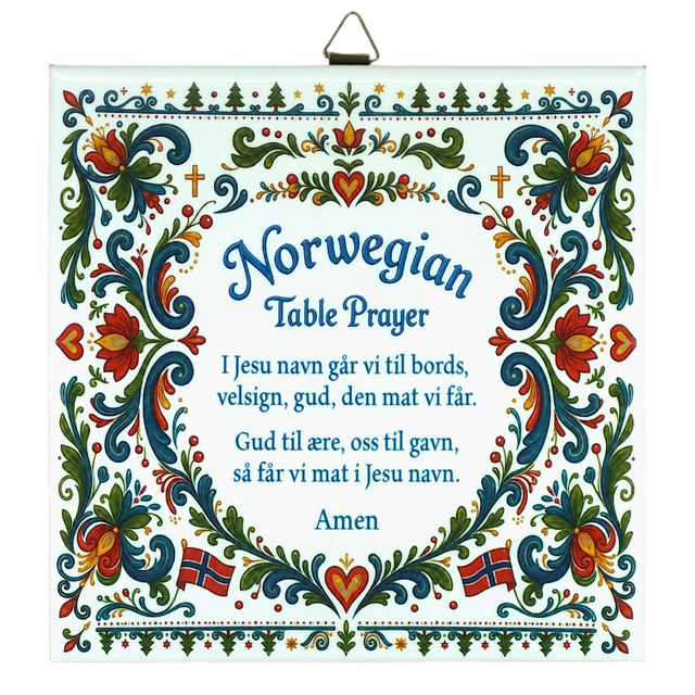 Ceramic wall tile featuring floral rosemaling patterns, Norwegian flags, and a Norwegian Table Prayer in blue text on a white background.