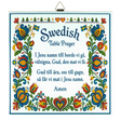Kurbits trivet featuring floral patterns, Swedish flags, and the Swedish Table Prayer printed in both Swedish and English, ending with the word “Amen.”.