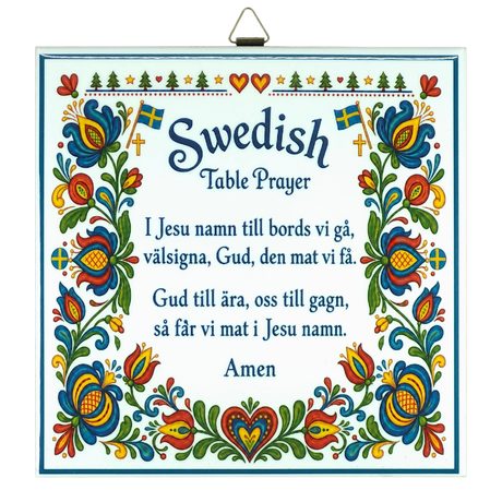 Kurbits trivet featuring floral patterns, Swedish flags, and the Swedish Table Prayer printed in both Swedish and English, ending with the word “Amen.”.