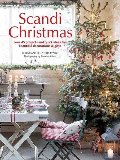 The cover of the book "Scandi Christmas" showcases a beautifully adorned tree next to a dining table embellished with candles and festive decor, perfectly encapsulating the charm and warmth of Scandinavian Christmas crafts.